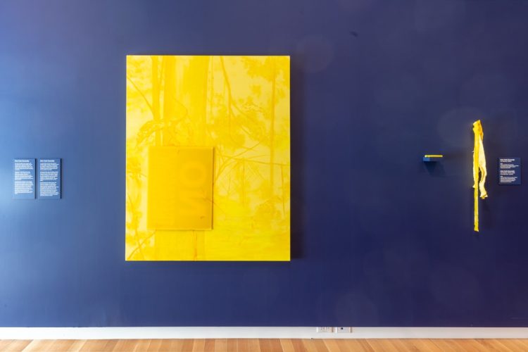 Erin Fyfe Donnelly, Act Natural: Yellow [Agis normalement : jaune], 2021, huile soluble à l’eau sur toile, affiche ondulée, ruban de signalisation, bâtonnets de peinture à éponge, peinture en aérosol et agrafes. Photo : Justin Wonnacott